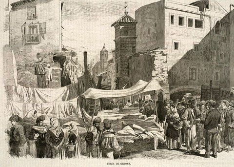 Mercat a la rambla de la Llibertat de Girona, on es fa la venda de queviures, teixits i altres productes. El mur que s'observa correspon al baluard de l'Areny, enderrocat el 1869. Al fons, la Catedral