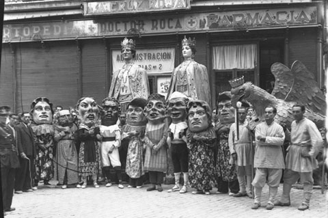 Els gegants, els capgrossos i l'Àliga de la Ciutat durant la festa de Corpus, juntament amb els ministrils, davant la farmàcia Roca, a la plaça de l'Oli