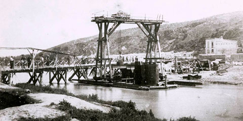 Obres de construcció del ferrocarril Girona-Frontera Francesa. Muntatge del pont del ferrocarril, sobre el riu Onyar. Al fons, el barri de Pedret i la muntanya de Montjuïc. 25 de juny de 1876