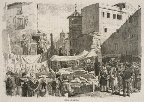 Mercat a la Rambla de la Llibertat de Girona, on es fa la venda de queviures, teixits i altres productes. El mur que s'observa correspon a les restes del baluard de l'Areny, enderrocat el 1869. 1870-1872