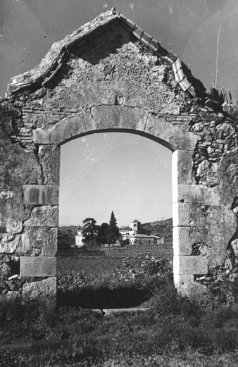 Restes d'una construcció. Al fons, el monestir. 1940-1950