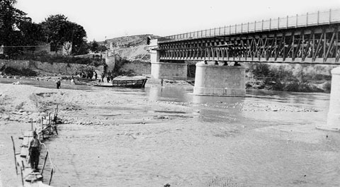 Vista del riu Ter a l'altura del Pont de la Barca, en fase de construcció. Sota el pont, la barca que dóna nom al pont. 1902