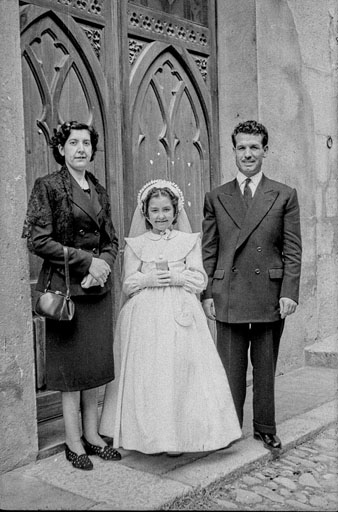 Primera comunió d'una nena a la capella del col·legi del Cor de Maria. Retrat de la família a l'exterior. 1952