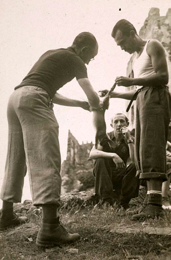 Homes escorxant un conill. 1940-1950