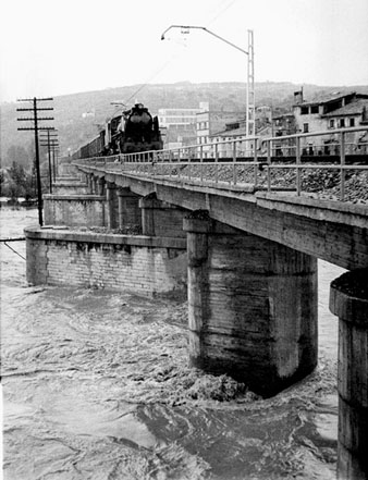 Inundacions a Girona provocades pel desbordament del riu Onyar, Ter i Güell. El pont del Ferrocarril amb una locomotora circulant. 13/09/1963