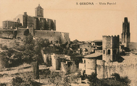 Vista de la Catedral de Girona des de la pujada de Montjuïc. En primer terme a la dreta, el monestir de Sant Pere de Galligants anexionat a la muralla. Al centre, el baluard de les Sarraïnes i l'espai que posteriorment ocuparia el passeig Arqueològic, amb la torre Cornèlia. Al fons a la dreta, el campanar de l'església de Sant Feliu. 1896-1915
