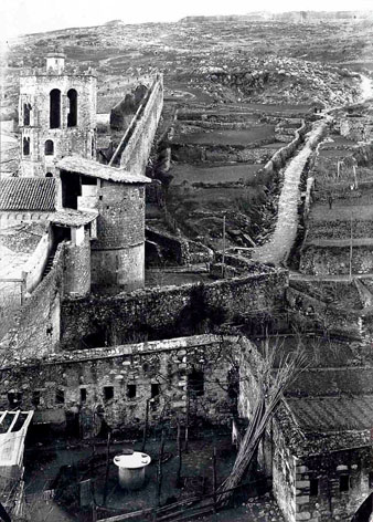 El monestir de Sant Pere de Galligants i el tram de muralla que enfila cap a la muntanya de Montjuïc. En primer terme, les restes del baluard de Sarraïnes, i al centre, el Tambor de Sant Daniel, que protegia el portal. Darrere el monestir, la torre de la capella de Santa Llúcia, i a la dreta, el camí vell de Montjuïc. Al fons, la muntanya i el castell de Montjuïc. 1910-1920