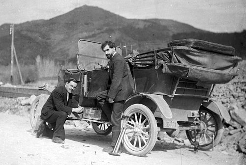 Miquel de Palol Felip acompanyat d'un altre home, canviant la roda d'un cotxe al camí de Bescanó, durant la construcció de les centrals d'Electroquímica Berenguer. 1912-1939