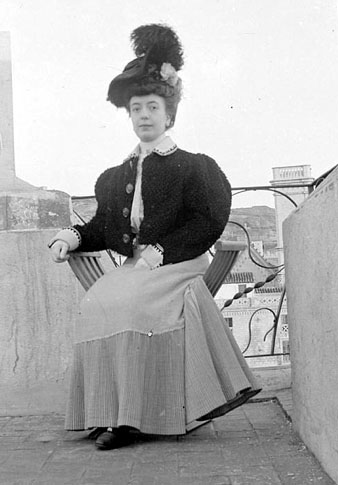 Retrat de Dolors Reitg Martí a dalt del terrat d'una casa d'un familiar al carrer Nou. Al fons s'observa el campanar de l'església del Sagrat Cor. 1900-1925