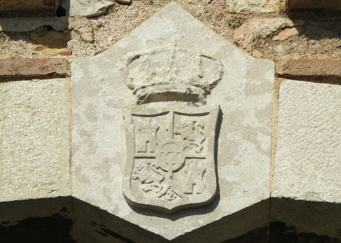 Escut al portal de l'edifici del Cos de Guàrdia. Es tracta de l'escut del rei d'Espanya, amb les armes de Castella (un castell), de Lleó (un lleó), de Granada (una magrana, a la part inferior) i al centre un òval amb tres flors de lis de la dinastía Borbó. Va ser usat des del regnat de Felip V fins al final del d'Isabel II (1868) i, de forma puntual, des de 1875 fins 1931 durant la II Restauració borbònica