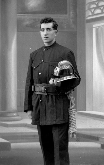 Retrat d'estudi d'un bomber vestit amb l'uniforme. 1920-1936