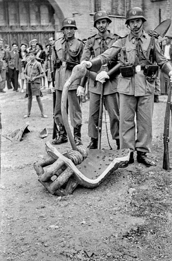 Plaça dels Apòstols de la Catedral de Girona. Militars al voltant de les restes de la campana Assumpta després de caure des del campanar durant la processó de Corpus. 20 de juny de 1946