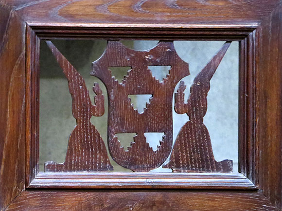 Detall del recolzabraços d'un reclinatori, amb els perfil de dues vestes de la Congragació de la Puríssima Sang