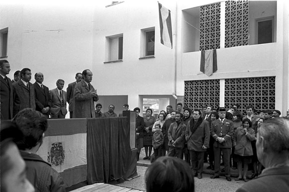 Acte de lliurament de claus dels pisos de protecció oficial del Grupo José Mara Prat al barri de Germans Sàbat. Discurs del delegat provincial de Sindicats, José Nuez de Castro. A l'esquerra, el governador civil de Girona, Victorino Anguera Sansó i l'alcalde de Sant Gregori, Emili Caula. 14 de desembre de 1970