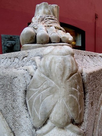 Detall del monòlit dedicat a la llegenda de la petjada de Sant Narcís a la cantonada del carrer de les Mosques amb el del Pou Rodó