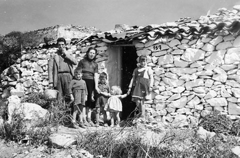 Barraquisme a la muntanya de Montjuïc. Barraques adossades al mur i a l'interior del castell. 1957