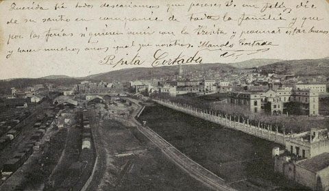 Vista des d'un punt elevat de les instal·lacions del ferrocarril amb l'antiga estació del tren al fons. A la dreta, la carretera de Barcelona amb la Residència de les Germanetes dels Pobres en primer terme. 1904-1905