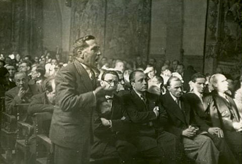 Intervenci&oacute; de Miquel Santal&oacute; a la sessi&oacute; de les Corts espanyoles celebrada al monestir de Montserrat l'1 de febrer de 1938. El del seu costat amb ulleres &eacute;s Llu&iacute;s Nicolau d'Olwer i al darrera, mig tapat, Josep Puig i Pujades