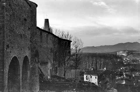 La torre Cornèlia i el campanar de l'església de Sant Feliu des del Passeig Arqueològic. A la dreta, la Casa Sarraïnes. Ca. 1960