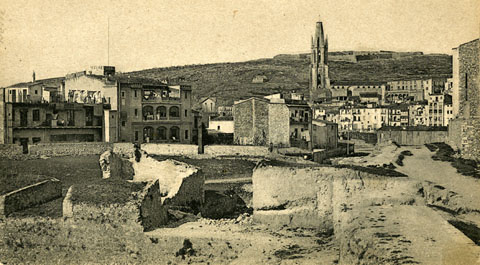 Vista parcial del baluard de la Santa Creu en ruïnes poc abans de la seva demolició definitiva. Al fons, la muntanya de Montjuíc amb el castell homònim i la torre de Sant Joan. 1905