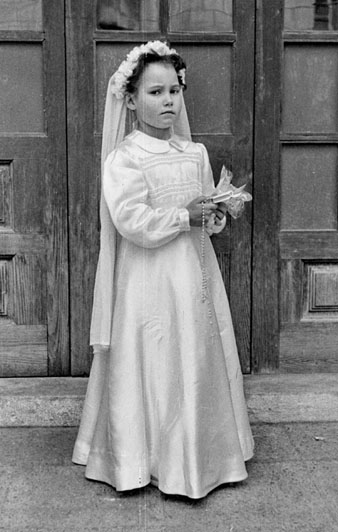 Primera comunió dels infants de l'Hospici. Retrat d'una nena al pati. 1951