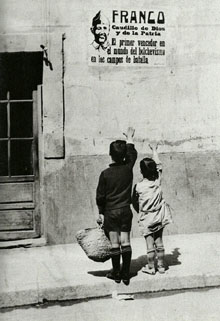 Nens saludant un grafit franquista. 1939-1940