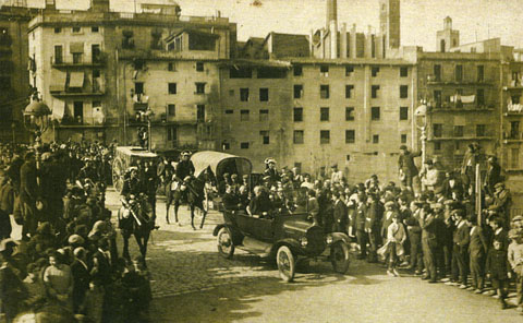 Visita de monsenyor Tadeschini, nunci del papa a Espanya, a la ciutat de Girona. Comitiva de rebuda del nunci al seu pas pel pont de Pedra, on s'observa al fons a la dreta una xemeneia de la fàbrica Grober, la torre de les Aigües i el campanar de l'església de Santa Susanna. 1928