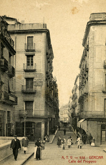 Encreuament dels carrers Santa Clara i Nou a latura del pont de Pedra. En primer terme, a la part superior esquerra, publicitat de lestudi de fotografia dAntoni García situat en el terrat de la casa Boué. Sobserva publicitat de la consulta del dentista Artur F. Roses a ledifici de lHotel Peninsular. 1905