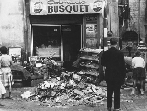Gent traient material afectat per les inundacions a l'exterior del Colmado Busquet, a la pla�a Catalunya. A la dreta, el carrer Albereda. 1962