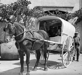 Tartana amb gent al pati d'una casa. 1922-1934