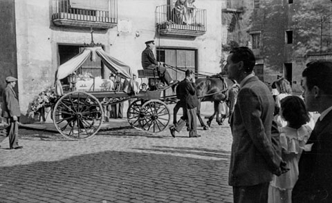 Seguici mortuori pel centre de la ciutat. Girona. S'observa el carruatge amb el taüt. 1950
