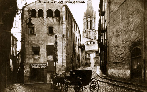 L'església i pujada de Sant Feliu vistes des de la part baixa. A l'esquerra, l'inici del carrer Calderers i la fusteria de Manuel Quer. 1911