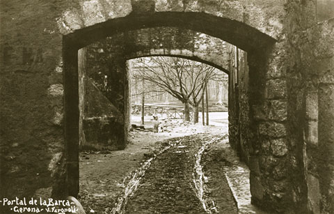El carrer del Portal de la Barca. Al fons, la passarel·la de fusta del mateix nom. 1911