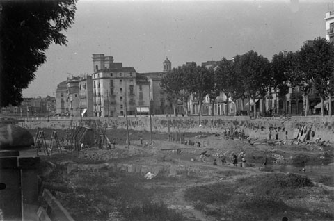 Obres de construcció del pont de l'alferes Huarte, que comunica la plaça Calvet i Rubalcaba amb el carrer del Carme. Obrers treballant al llit del riu Onyar.