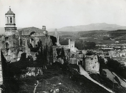 Vista des de Torre Gironella. En primer terme, les restes de la Caserna d'Alemanys. En segon terme al centre, el portal i la capella de Sant Cristòfol. Al fons a l'esquerra, la Catedral de Girona, al centre, la torre Magdala als Jardins de la Francesa i a la dreta, el barri de Sant Pere de Galligants. 1900-1930