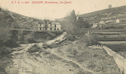 Vista de la vall de Sant Daniel des del camí homònim. Al centre, entre els arbres, el monestir de Sant Daniel. Al fons a la dreta, la muntanya de Montjuïc i la torre Suchet