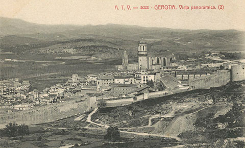 Vista panoràmica de la ciutat de Girona des de la muntanya de les Pedreres. En primer terme, el tram de la muralla de les Pedreres comprés entre la torre del General Peralta i la torre del Peix. En segon terme, el barri Vell on destaca el Seminari Diocesà i el convent de Sant Domènec al centre. Al fons sobresurten el campanar de lesglésia de Sant Feliu i la Catedral de Girona. 1905-1909