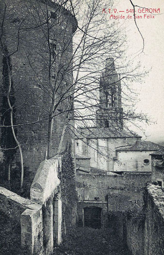 Vista de l'absis i el campanar de l'església de Sant Feliu des de l'espai paral·lel a la muralla que posteriorment ocuparia el passeig Arqueològic. En primer terme a l'esquerra, la torre Cornèlia. 1905-1911