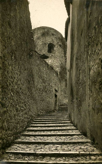 El carrer Escola Pia, al barri Vell. Al centre, la torre del Vescomte, entre la Casa Agullana i el solar dels Maristes. 1930-1940