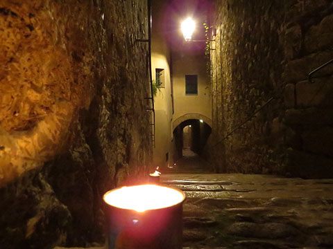 El carrer de Sant Lloren&ccedil; amb espelmes guiant cap al Pati dels Rabins, escenari de les representacions teatrals