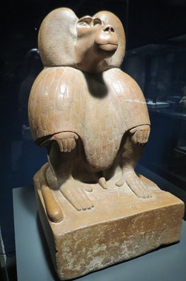 Figura d'un babu&iacute; a la gatzoneta. Quarsita vermella. Dinastia XVIII, regnat d'Amenhotep III, Ca. 1390-1352 aC