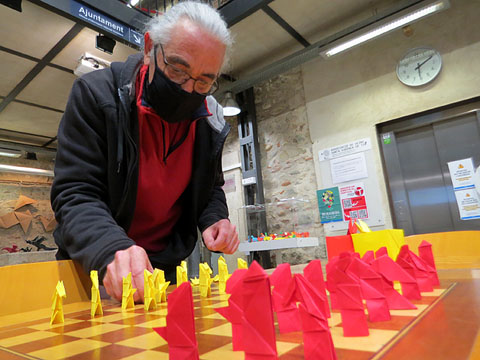 Jordi Pericot muntant al tauler les peces d'un joc d'escacs fet amb la tècnica de l'Origami