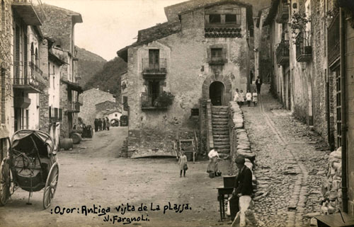Vista de la pla&ccedil;a d'Osor. En primer terme s'observa una tartana en un rac&oacute; de la pla&ccedil;a. 1918